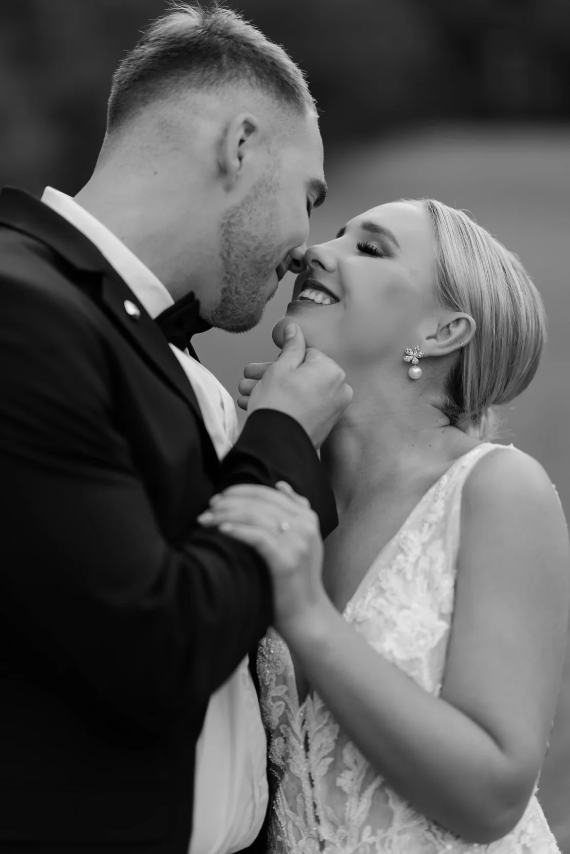 Groom holding bride's chin for a kiss in black and white, Pretoria wedding